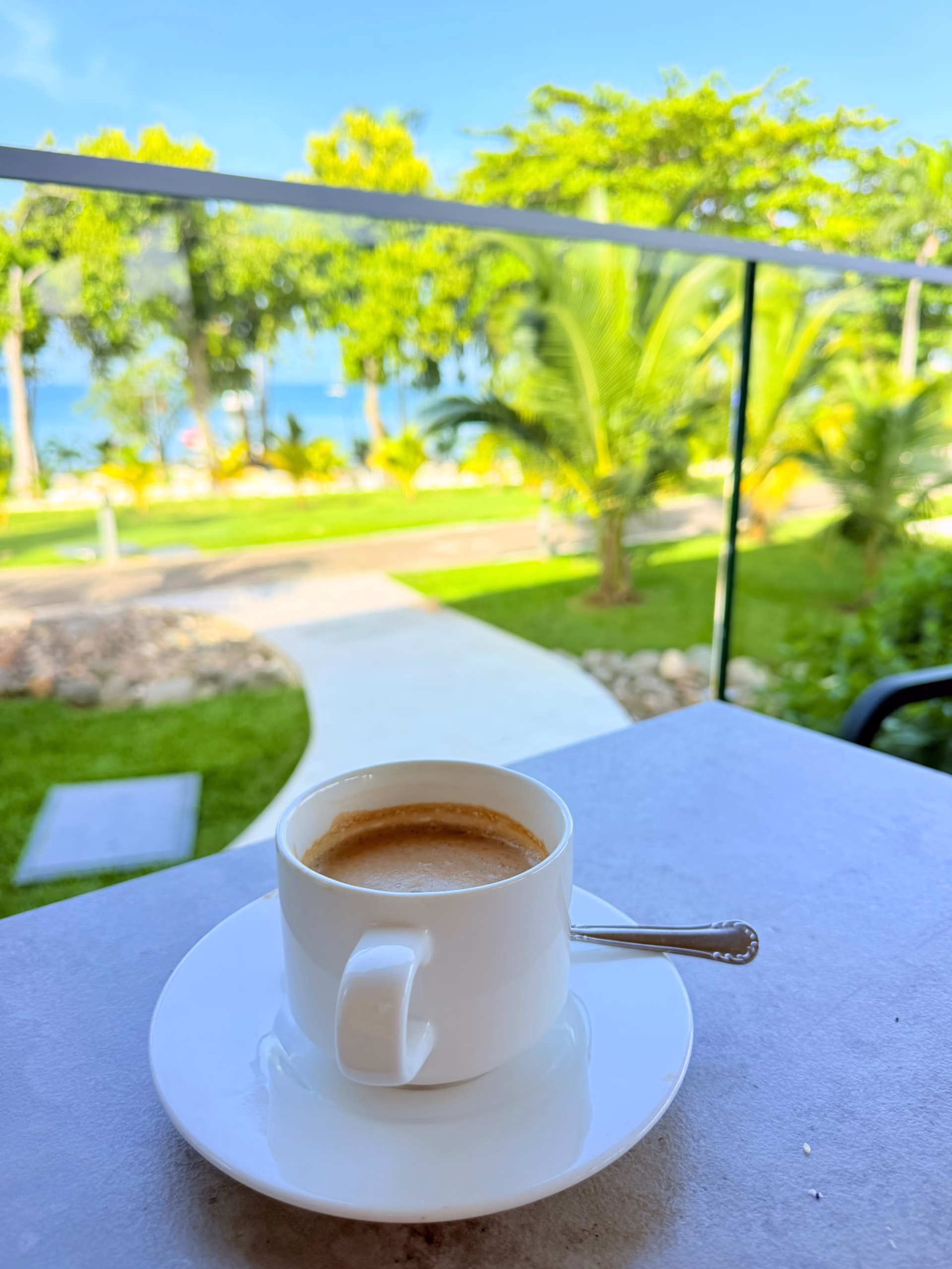 A cup of coffee overlooking green resort grounds in Negril