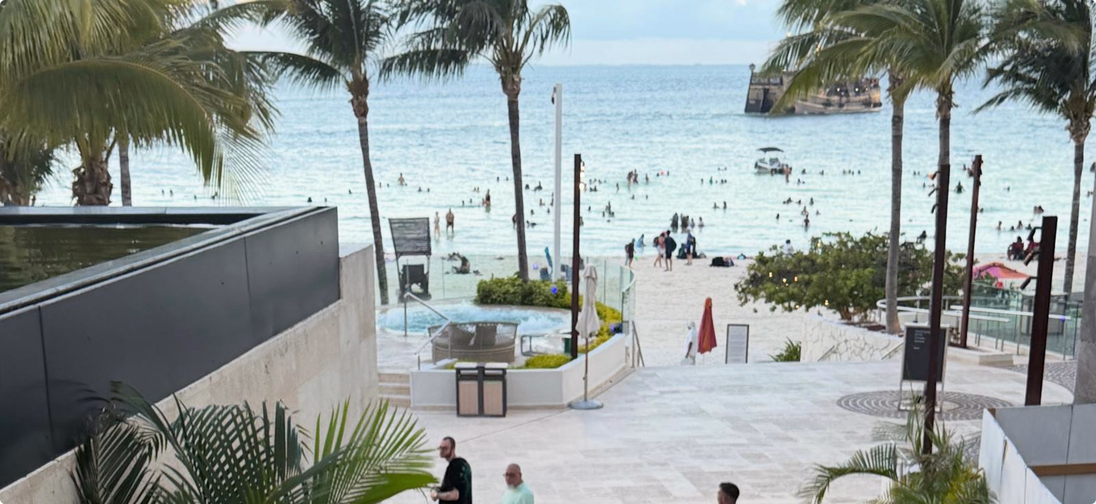 חופשה במקסיקו Elevated view over a Cancun hotel terrace toward the beach and Caribbean Sea
