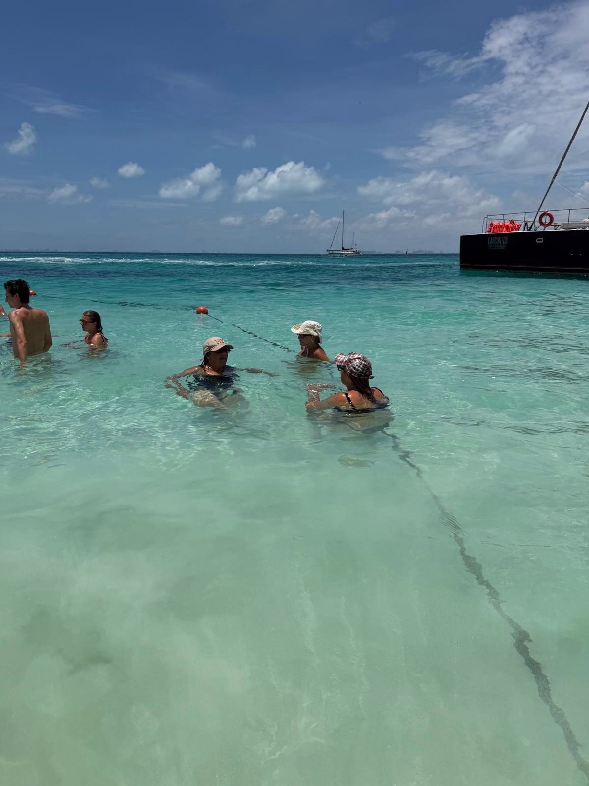 חופשה במקסיקו Members of the group standing together in shallow turquoise Caribbean water