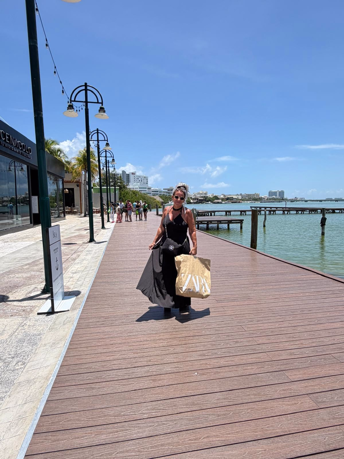 חופשה במקסיקו Traveler walking along a waterfront boardwalk in Cancun during the group trip
