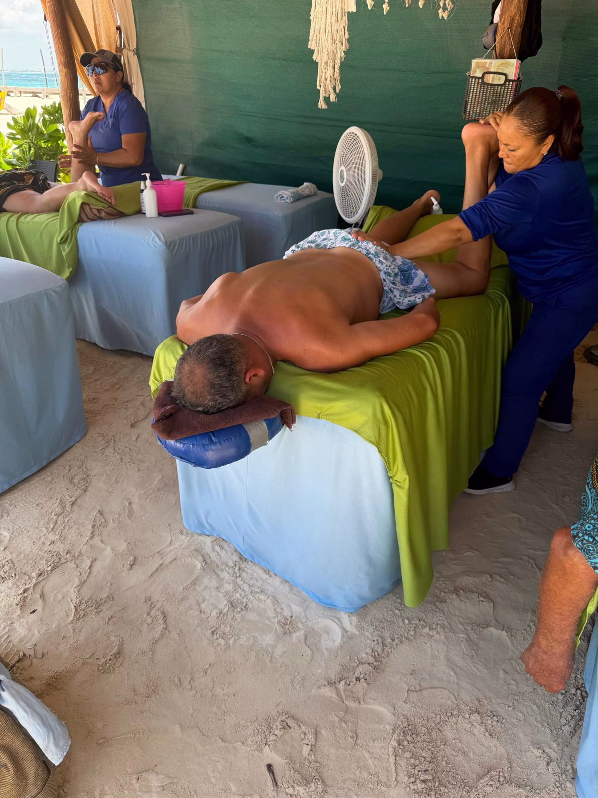 חופשה במקסיקו A traveler receiving a massage on the beach during the Mexico trip