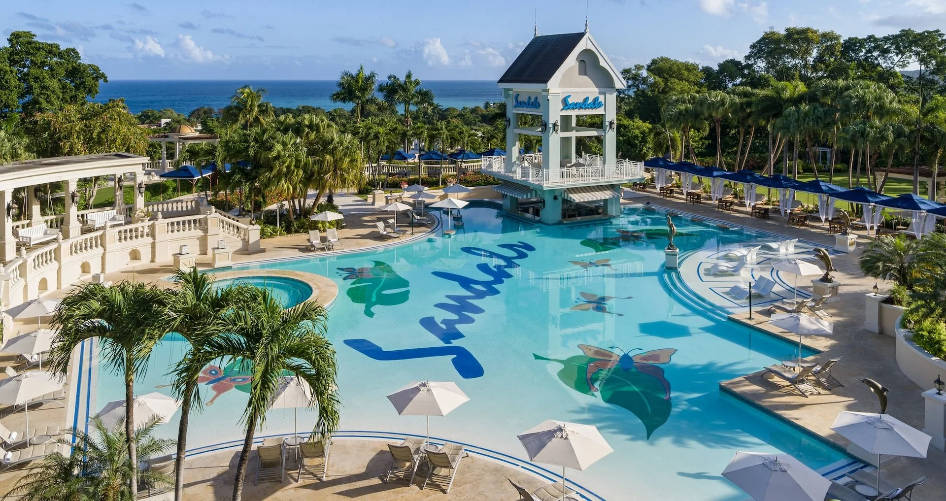 בריכה מול הים ואזור ישיבה ב־Sandals Ochi Beach Resort