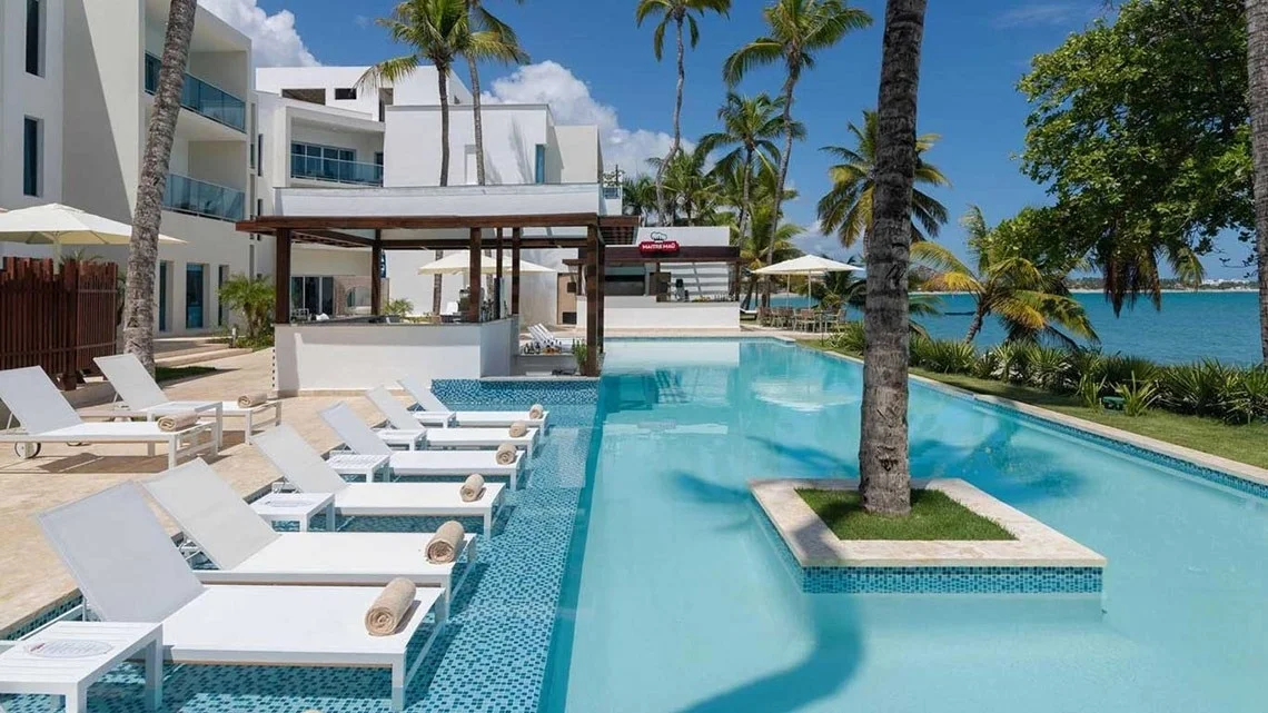 בריכה מול הים ואזור ישיבה ב־Presidential Suites Cabarete